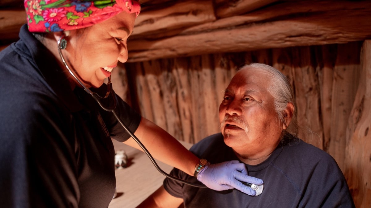 A nurse checking a patient's heart beat