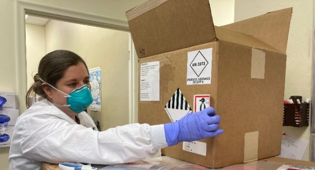 An LLS fellow examines a box of hazardous material.