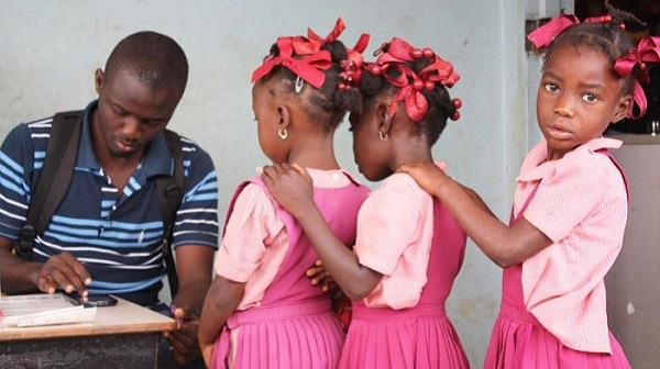 Three girls registering for a mass drug administration campaign.