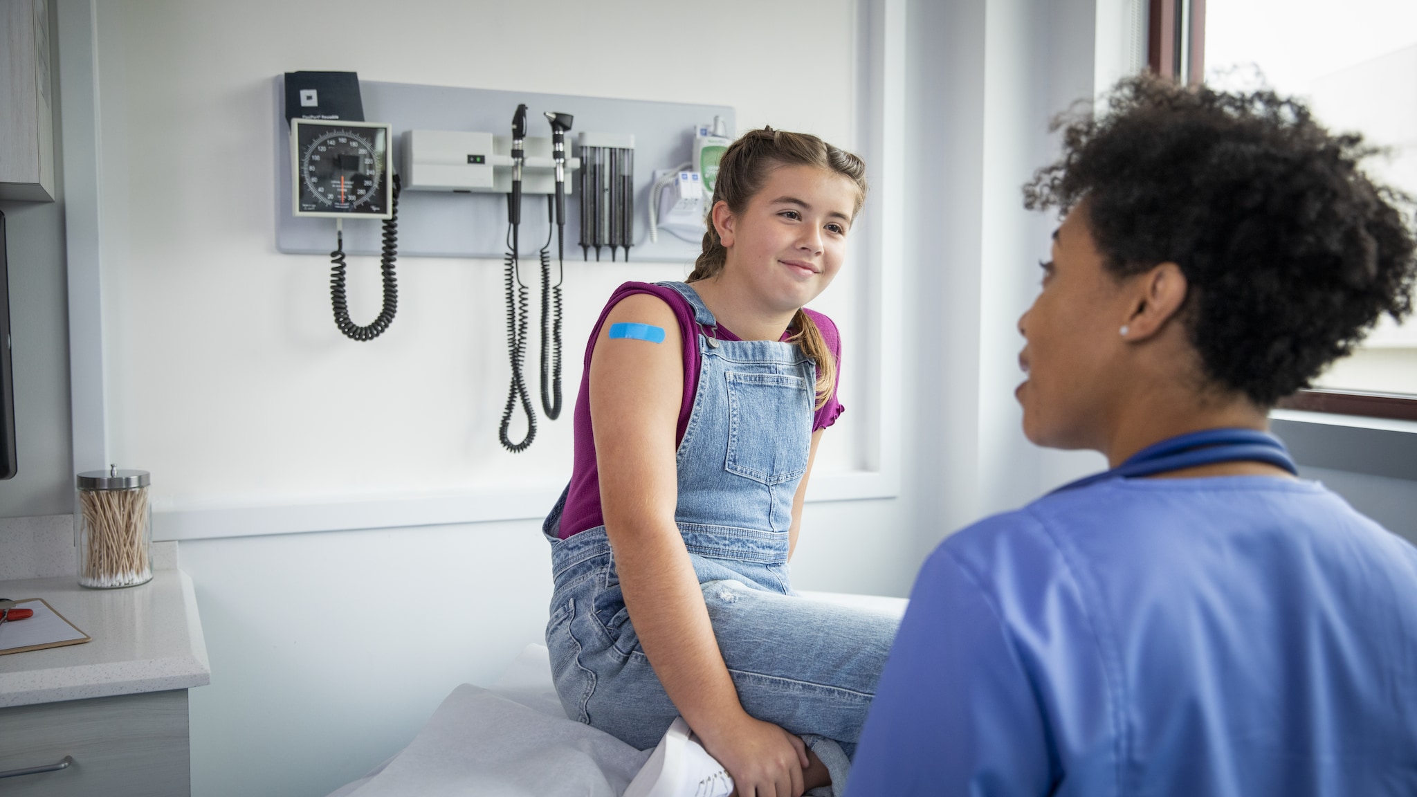 A pediatric patient talks with healthcare provider after receiving vaccination.