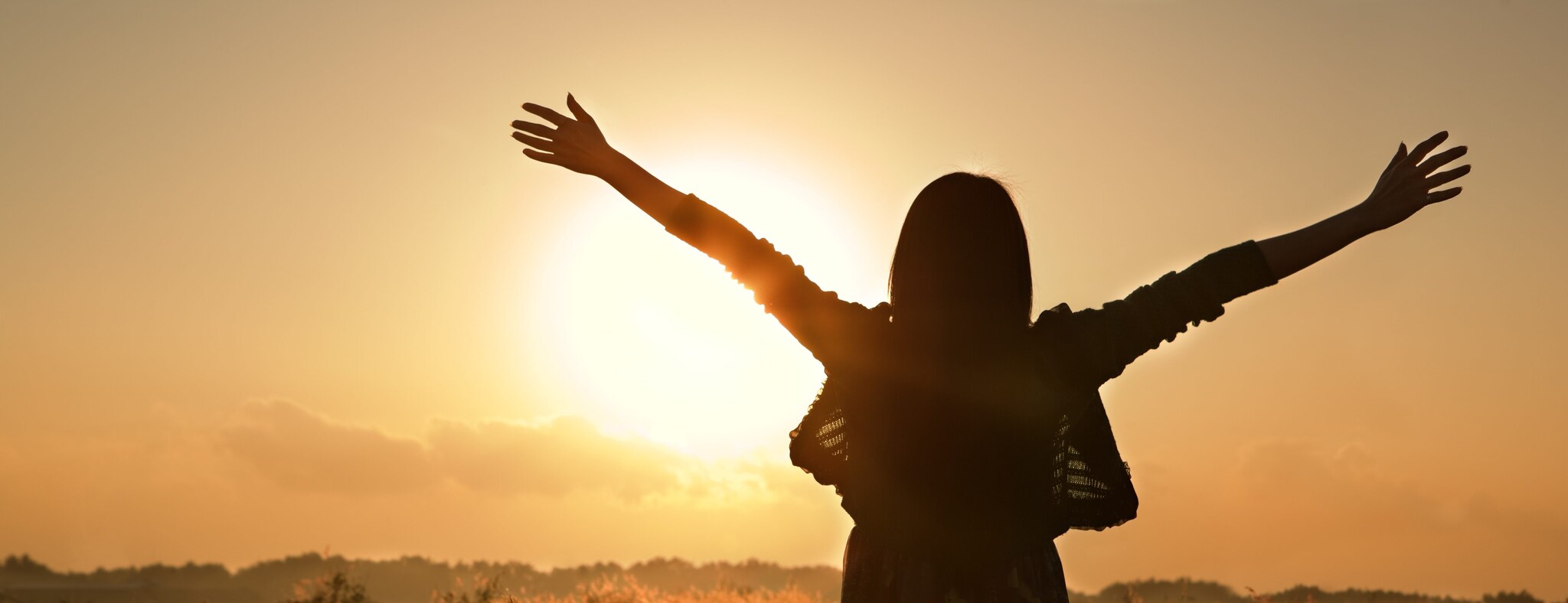 Silhouette of a person with the sun low in the sky