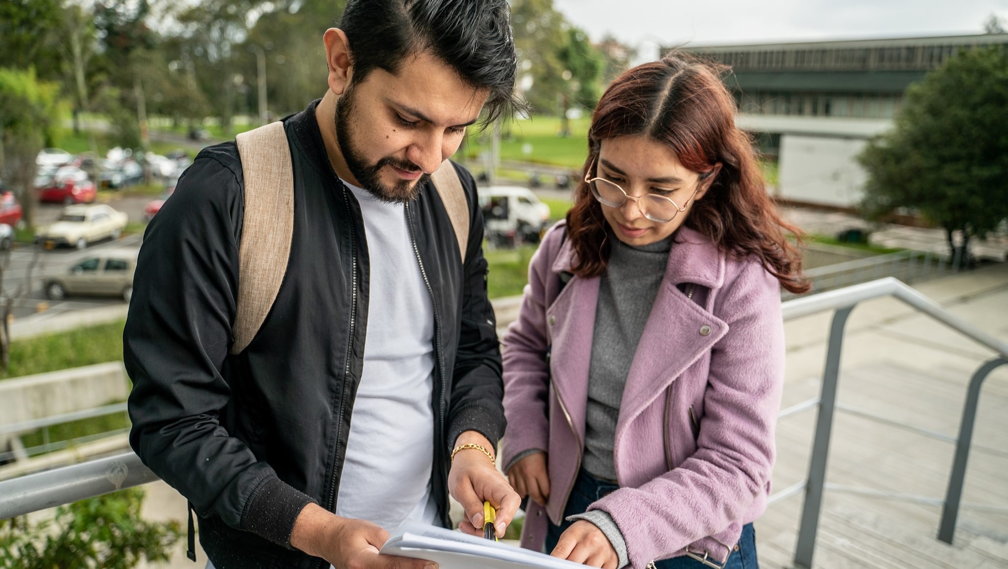 Dos personas al aire libre mirando un informe.