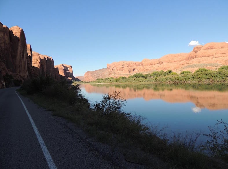 A road surrounded by mountains and a river.