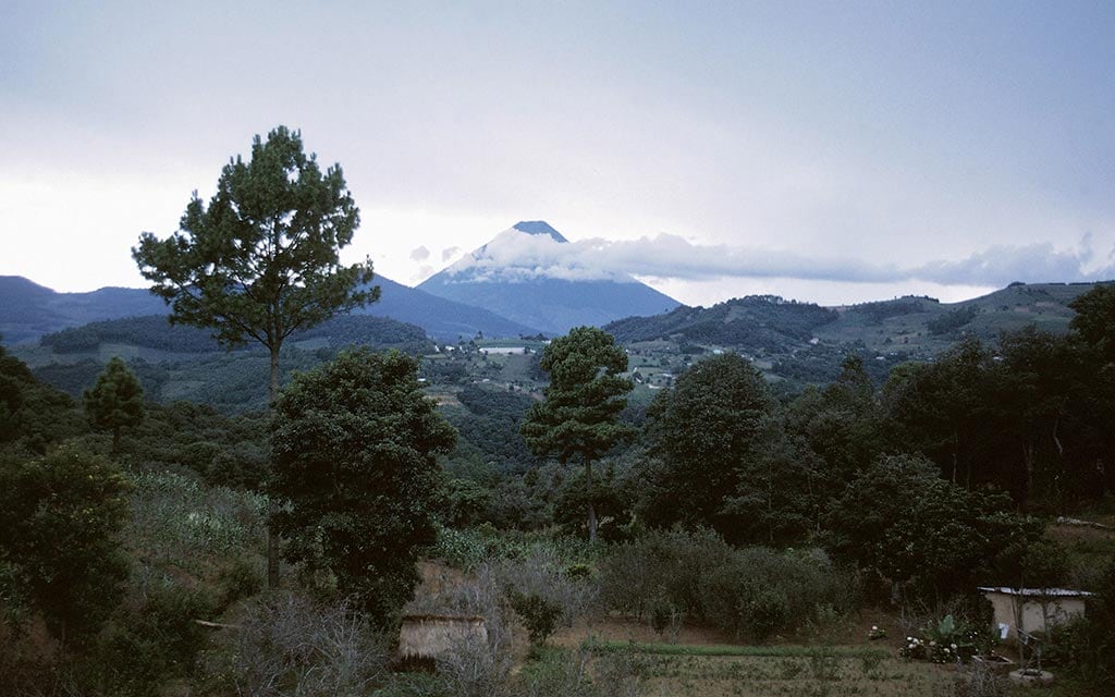 A village in the woods surrounded by mountains.