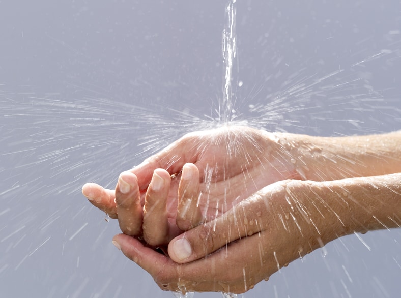 A person holding their hands under running water.