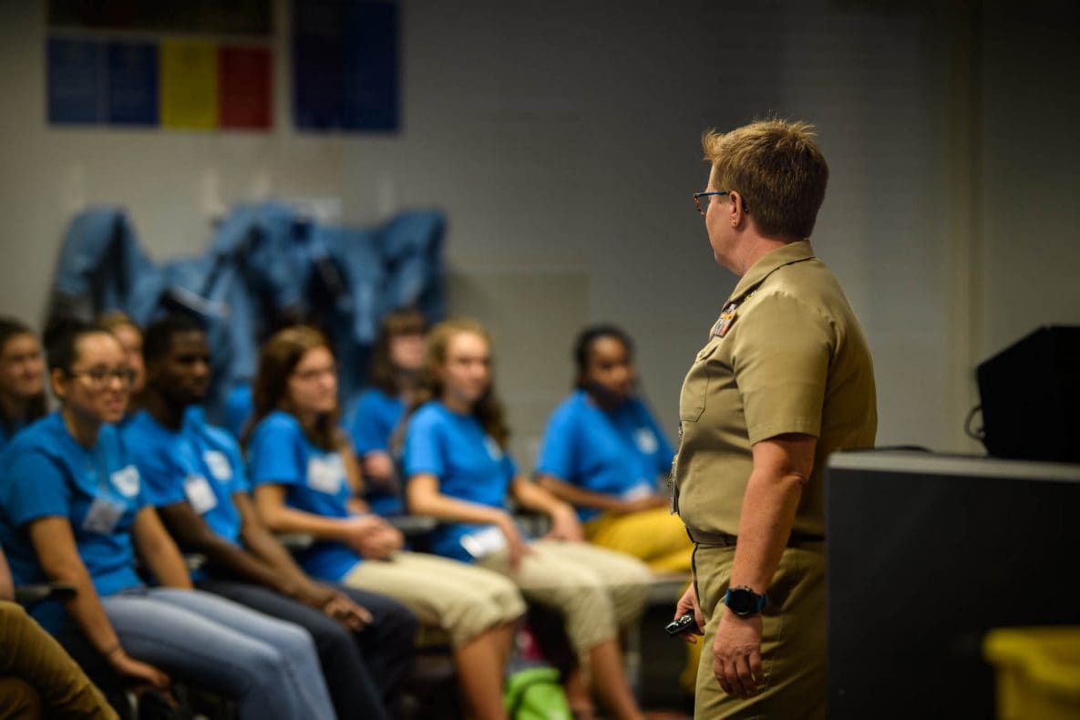 Adult speaking to seated students