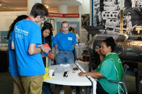 Four students speaking to adult