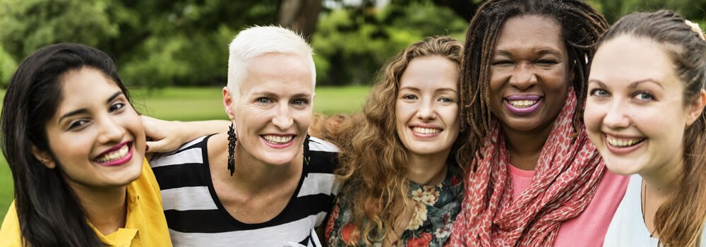 Image of five women standing together and laughing