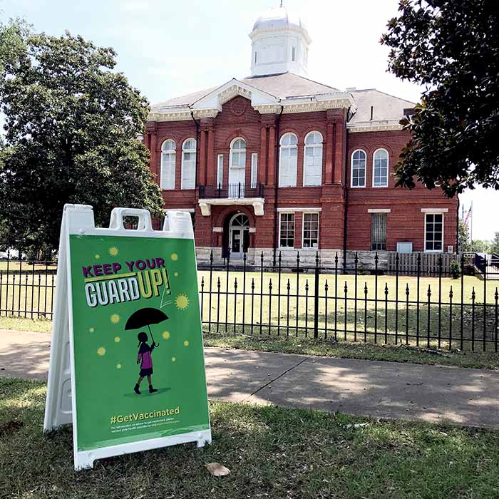 photograph of “Keep Your Guard Up” sign on sandwich board outside of courthouse in Sumpter County