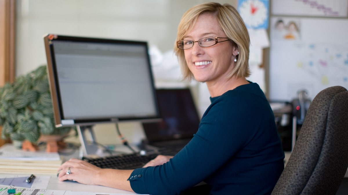 a woman using a computer in an office