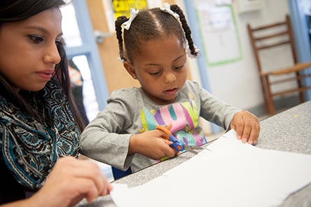 A 4-year-old girl using scissors