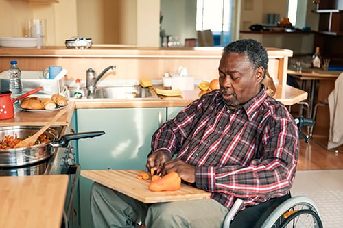 Senior Afro-American in Wheelchairs is Preparing a Lunch at Home