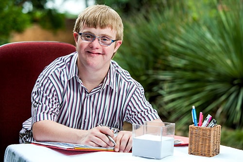 A disabled man working at his desk.