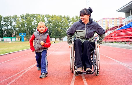 Woman in a wheelchair with a child getting ready to run