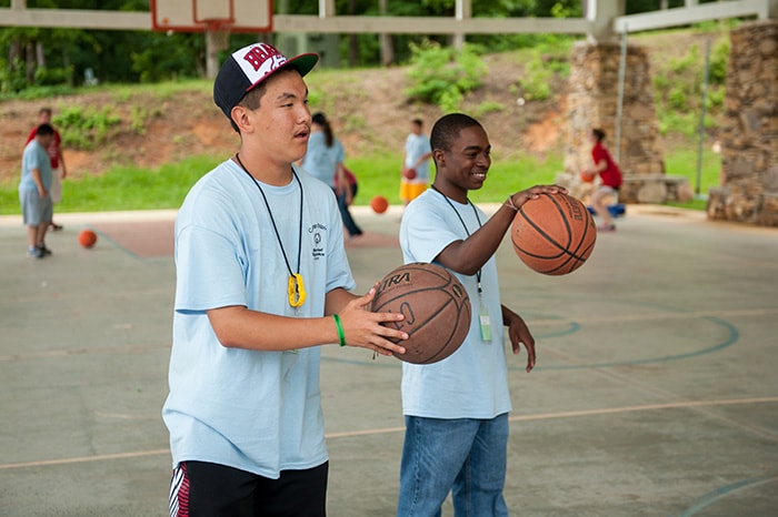 Two boys playing basketball.