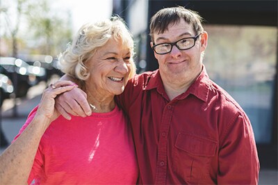 A man with disabilities with his arm around a woman