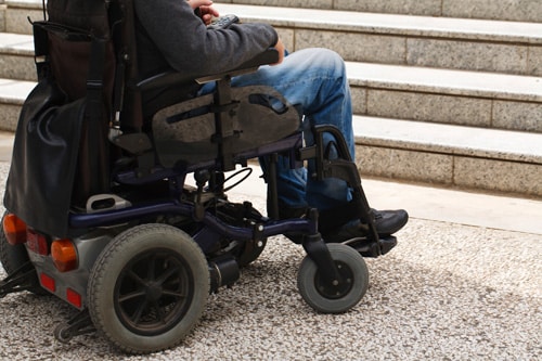 Person in a wheelchair at the bottom of steps.