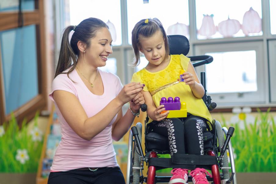 Caregiver taking care of child in wheel chair