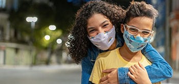 Mom and son hugging wearing masks.