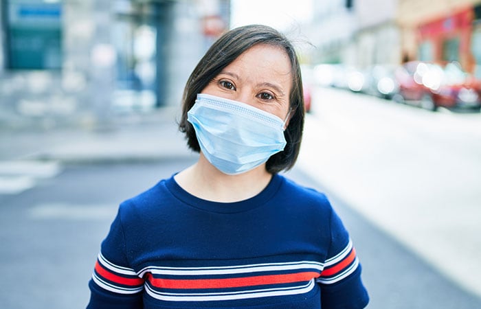 A woman with down syndrome wearing a protective face mask