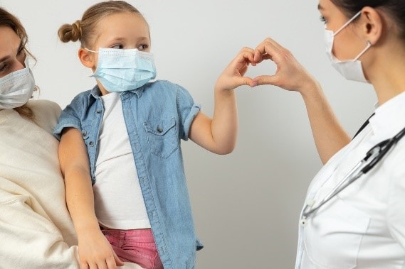 A mother and daughter with protective masks visiting the doctor.