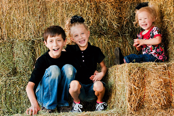 Kids sitting on a haystack