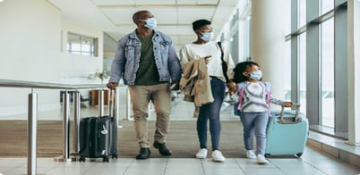 An African-American family walking with their luggage