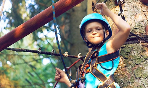 Little boy in a protective helmet and in special equipment playground