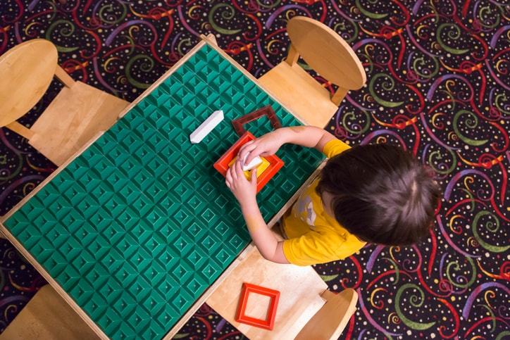 Overhead of Boy Playing With His Toys at Table