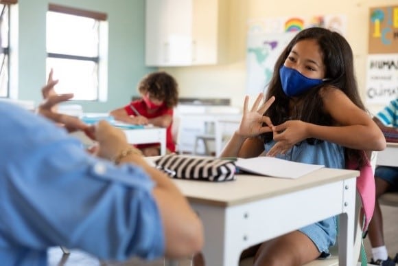 A girl at school communicating with sign language