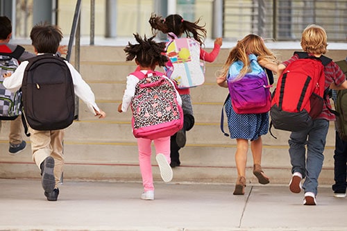 Kids running with backpacks on