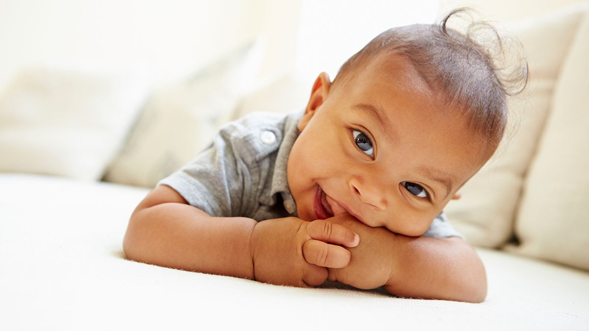 A happy baby laying on his stomach