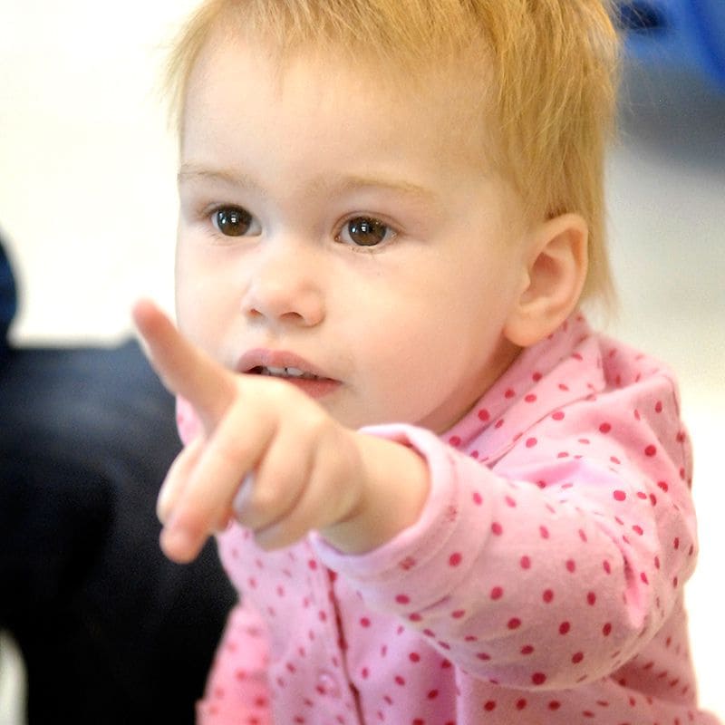 A toddler points to what she wants.