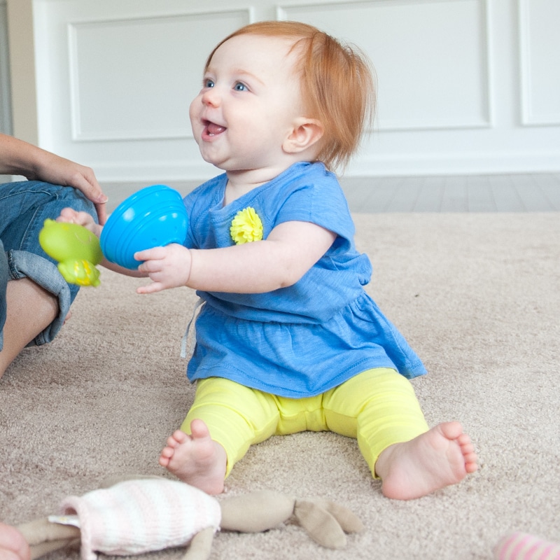 A young girl bang her toys together