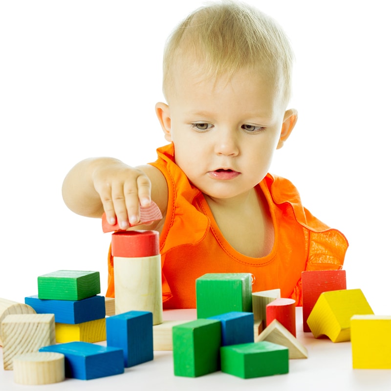 A boy builds a tower out of blocks.