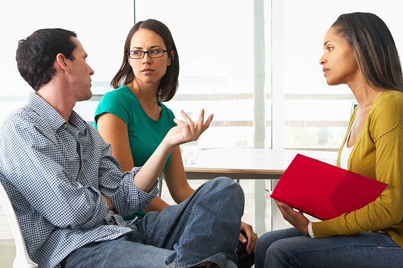 Una proveedora de cuidados infantiles habla con los padres.