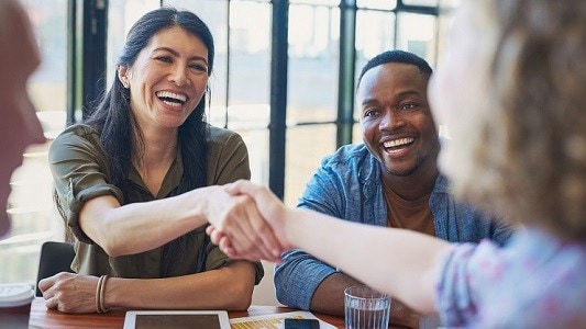 Professionals at a table shaking hands