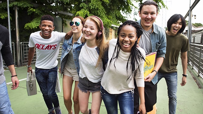 Diverse group of teenagers laugh facing the camera