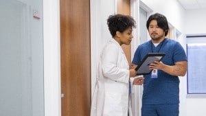 Doctor and nurse talking in hospital hallway