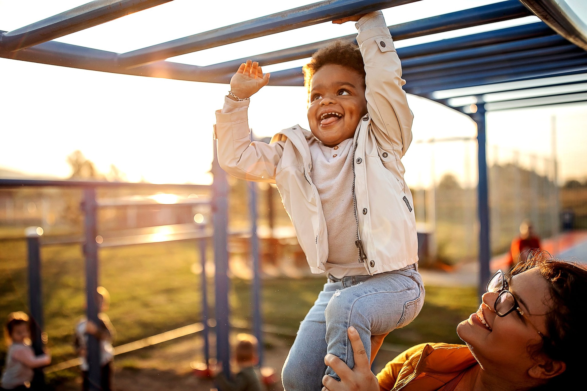 Happy child plays on playground with mom