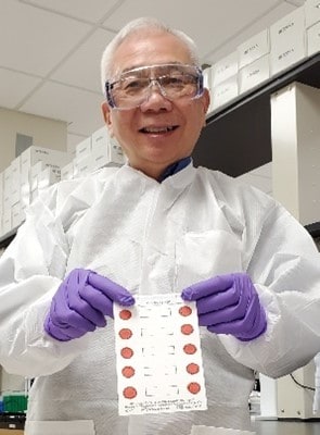 CDC Research Microbiologist Francis Lee holding dried blood spots