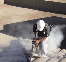 Worker creating a large cloud of dust while cutting