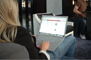 A young-looking woman with long blond hair sits on a chair in what looks to be an internet caf%26eacute;.