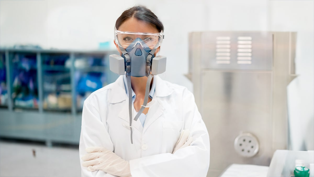 Woman in white coat wearing PPE