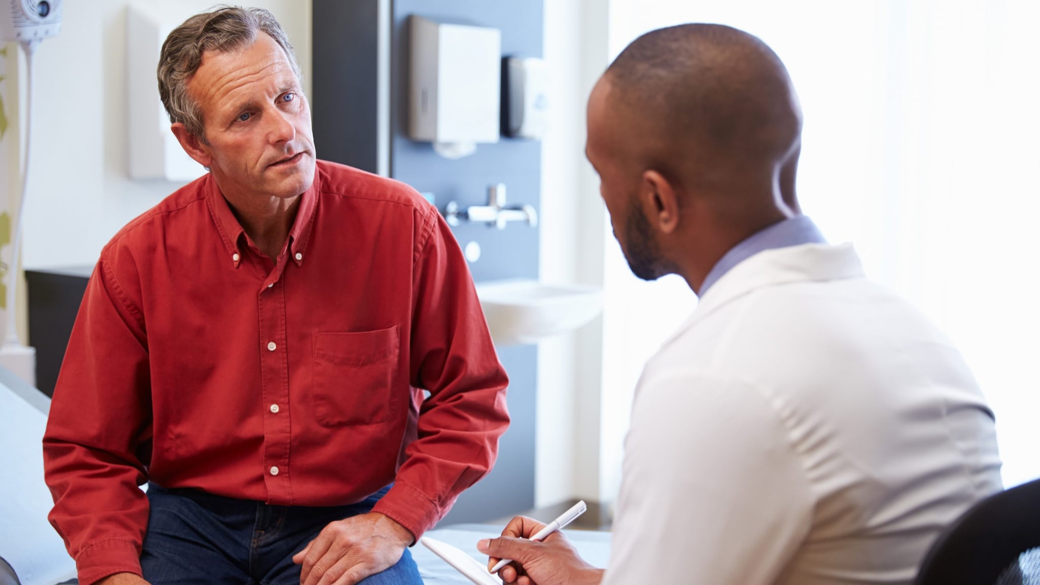 Doctor talking with patient and taking notes.