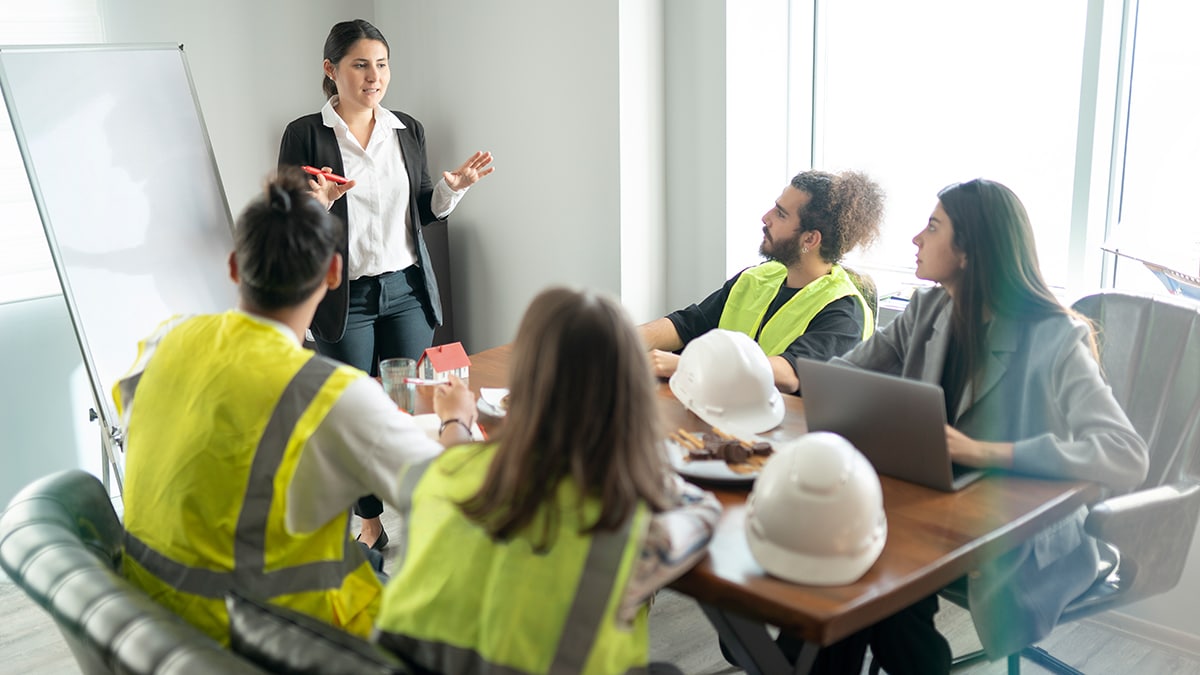 woman standing in front of table of workers