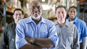 Four workers of various ages in a warehouse