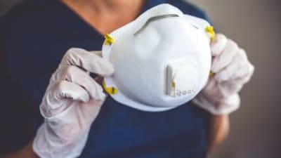 Nurse holding a NIOSH-approved N-95 respirator.