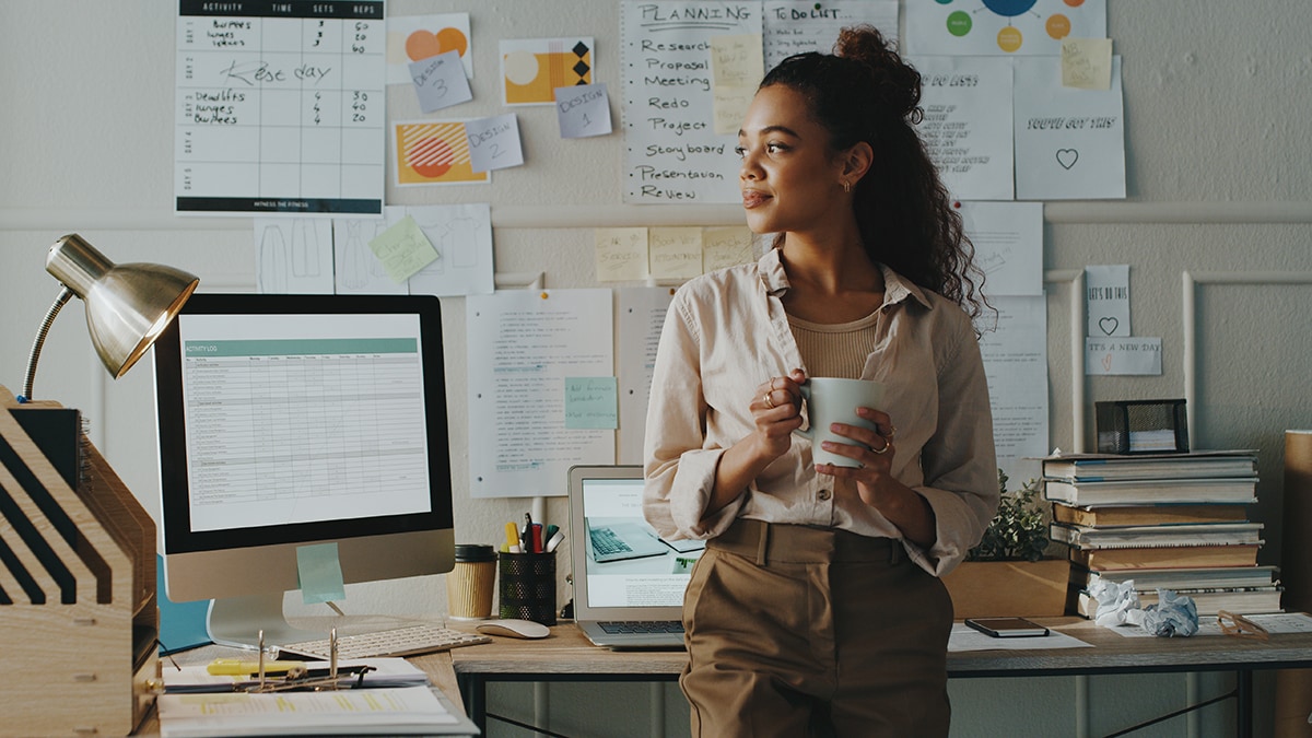 Work in office holding a coffee cup looking hopeful