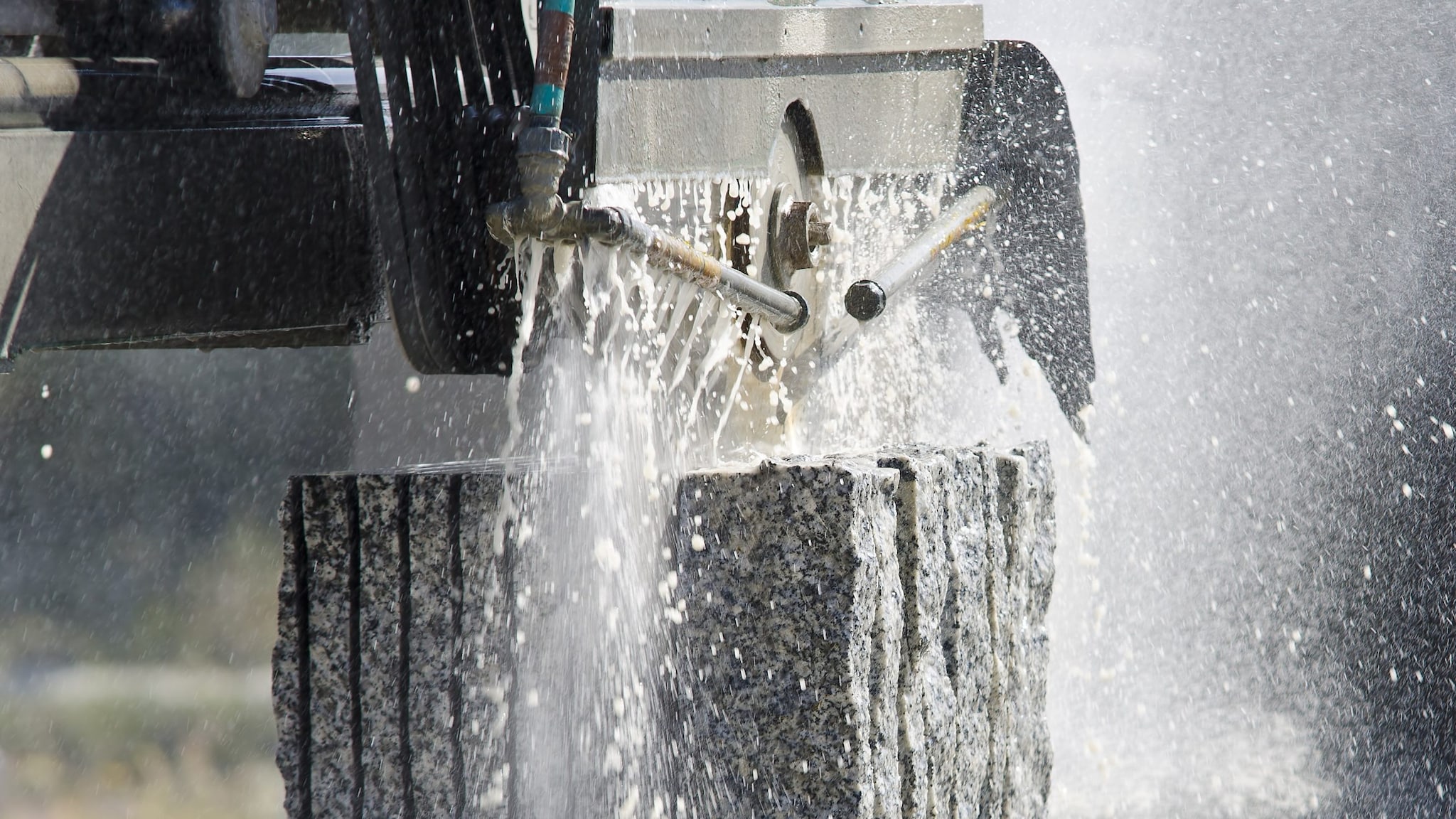 Water spraying method being used to cut a stone block.